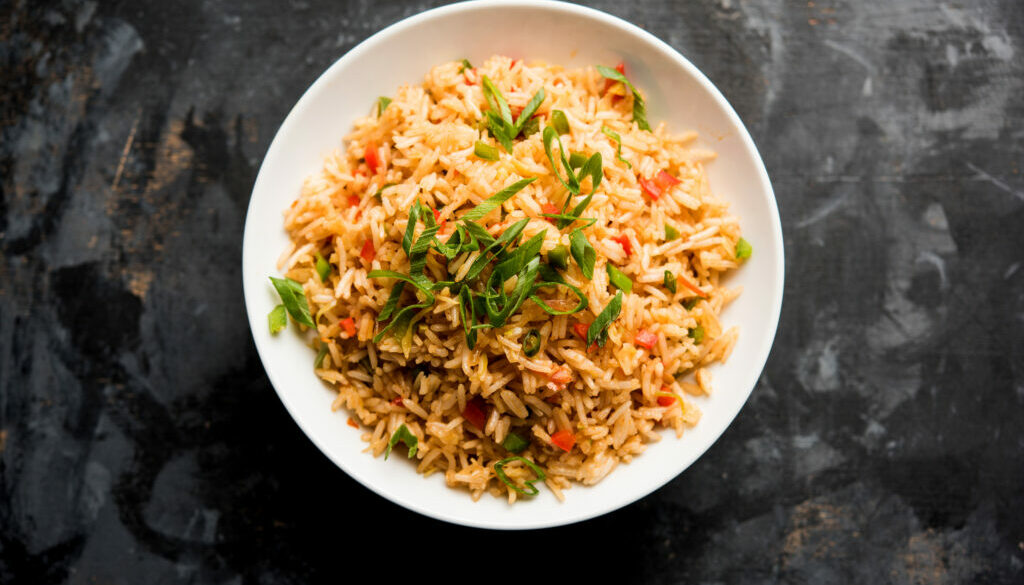 Schezwan Fried Rice Masala is a popular indo-chinese food served in a plate or bowl with chopsticks. selective focus