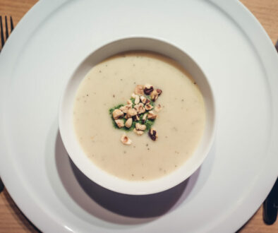 Sunchoke soup with roasted peanuts in white bowl