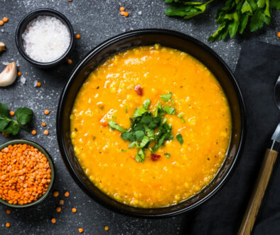 Red lentil soup on black top view.